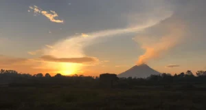 ein rauchender Vulkan in der Abendsonne