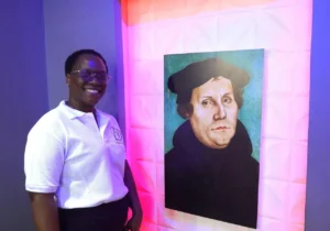 Eine Christin aus Tansania vor einem Lutherbild. Der gemeinsame christliche Glaube verbindet Menschen über kulturelle Grenzen hinweg.