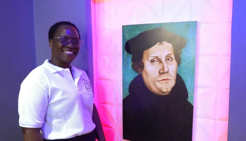 Eine Christin aus Tansania vor einem Lutherbild. Der gemeinsame christliche Glaube verbindet Menschen über kulturelle Grenzen hinweg.